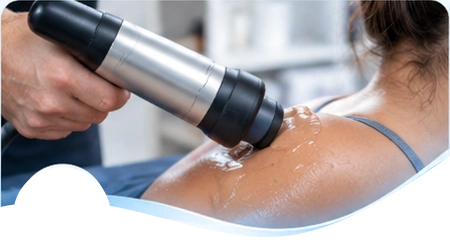 Handheld therapy applicator applied to a patient’s shoulder.
